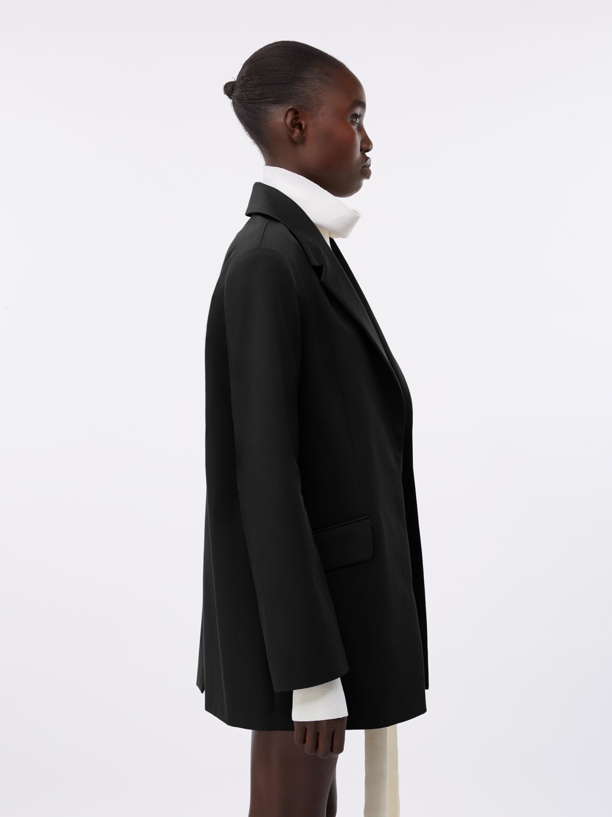 close up of a model wearing a black square blazer
