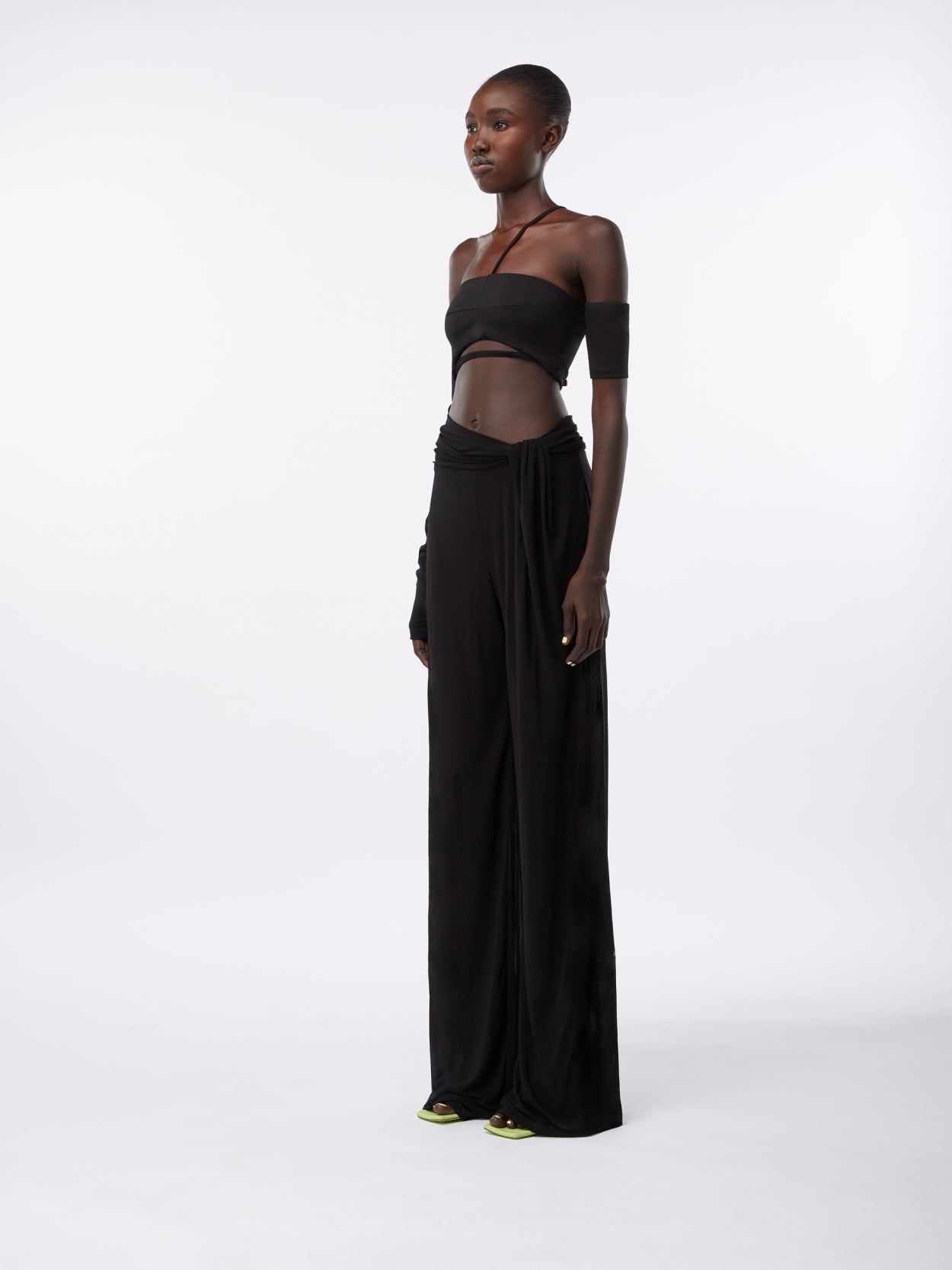 model wearing black draped trousers with twist detaill